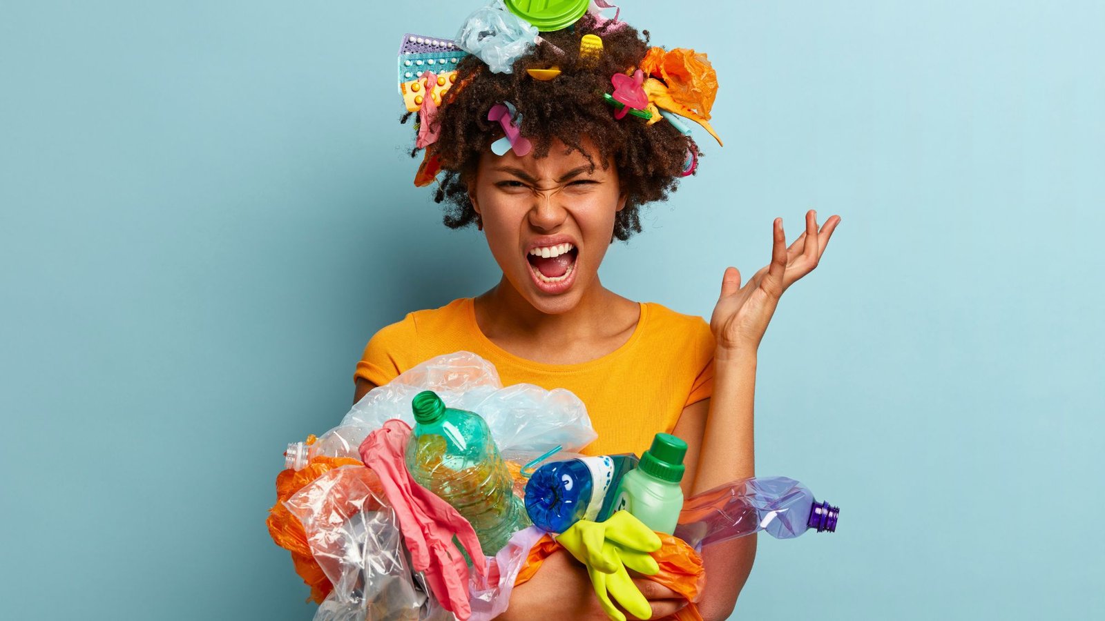 A Girl holding lots of different trash looking for managing waste and rubbish